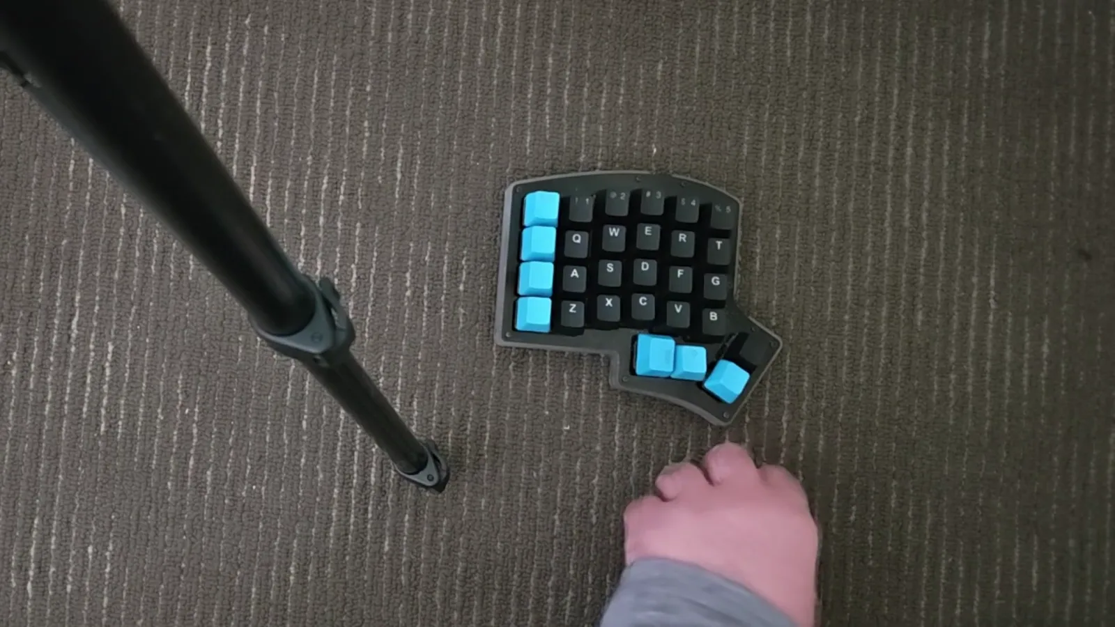 Default keybind layout Compact left-hand keypad with blue keycaps marking the default In Falsus lane keys